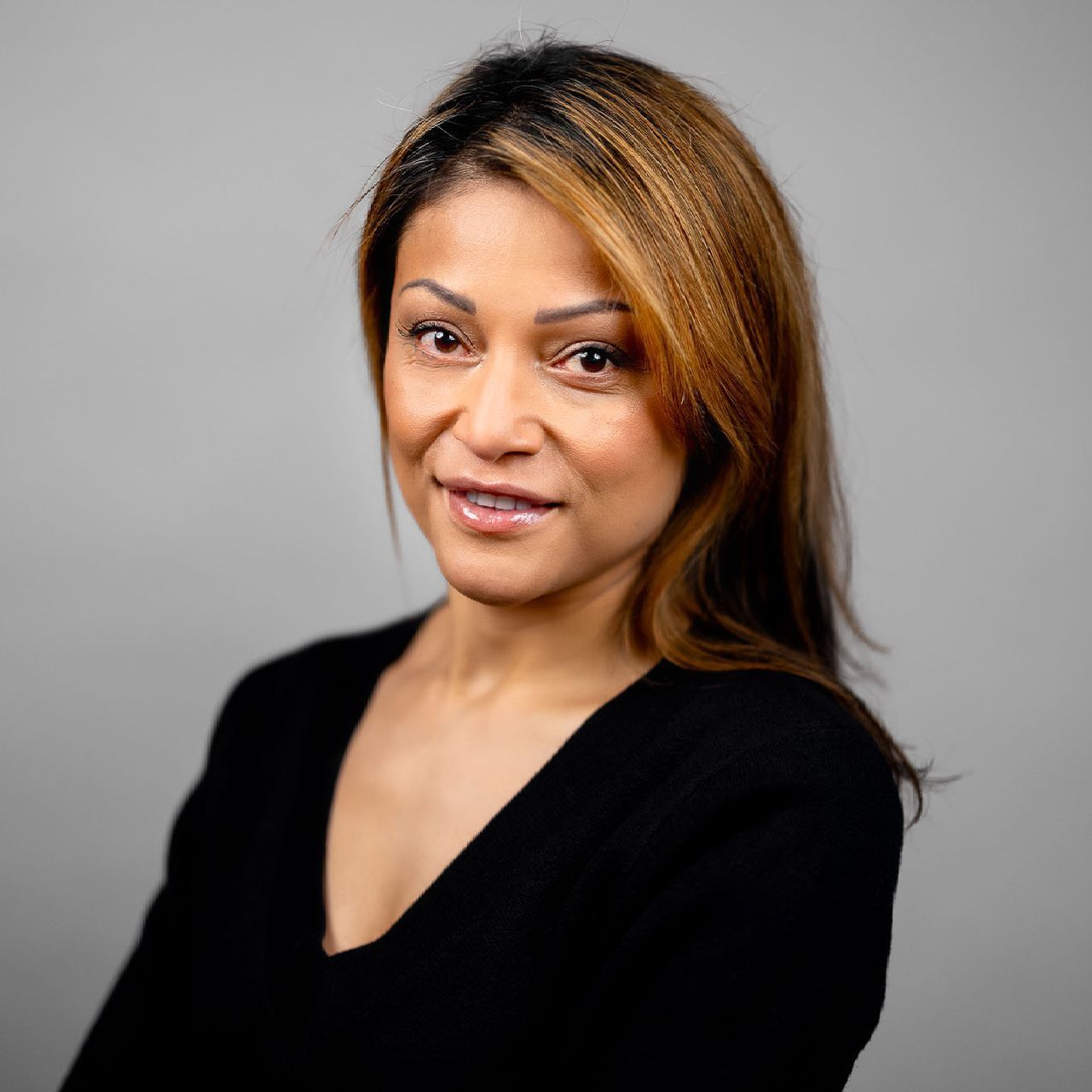 The woman is wearing a black shirt and smiling for the camera.