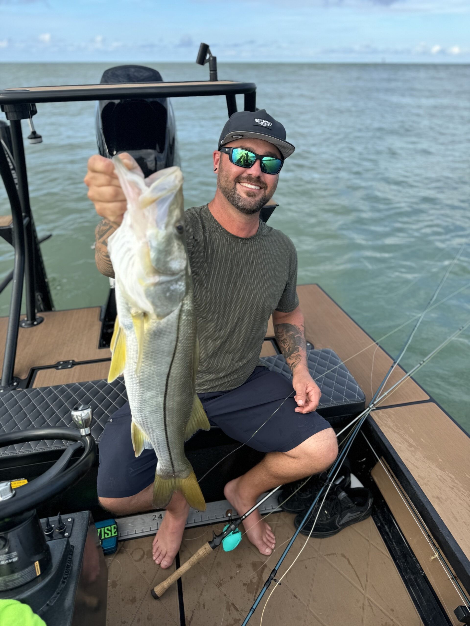 A man is sitting on a boat holding a fish.