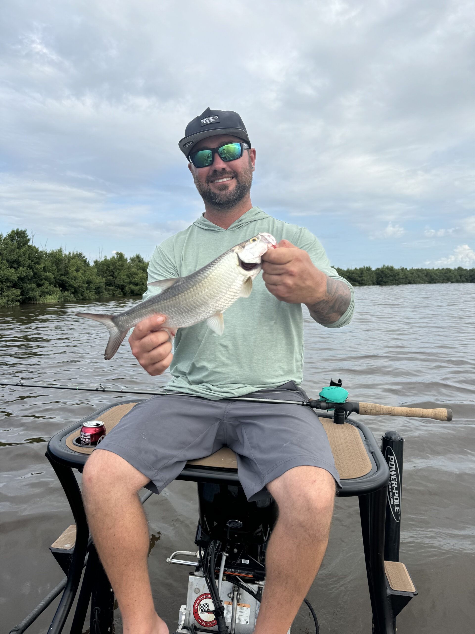A man is sitting on a boat holding a fish in his hands.