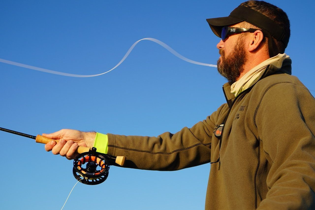A man with a beard is fishing with a fly rod