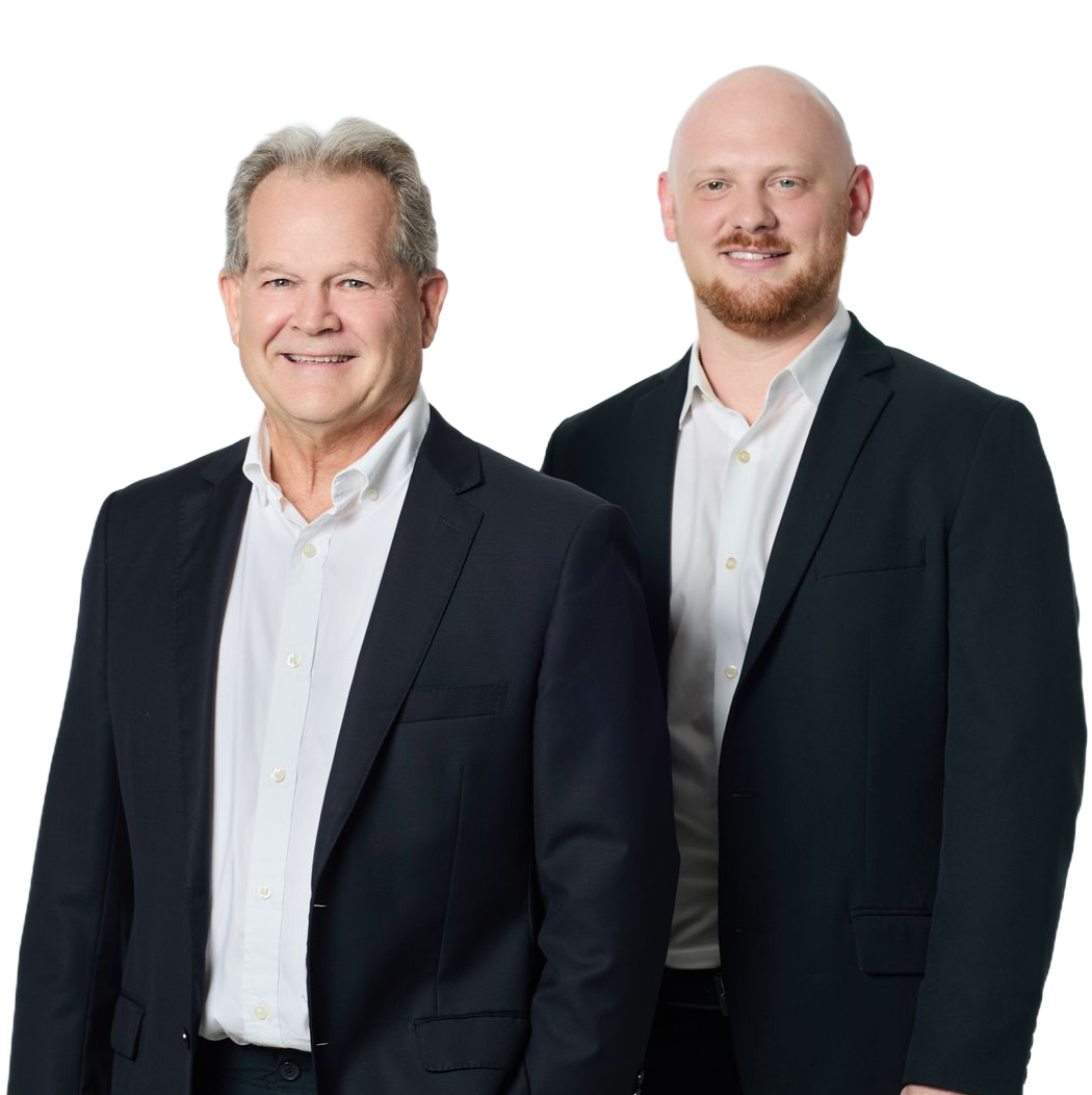 Two men in dark suits posing against a white background.