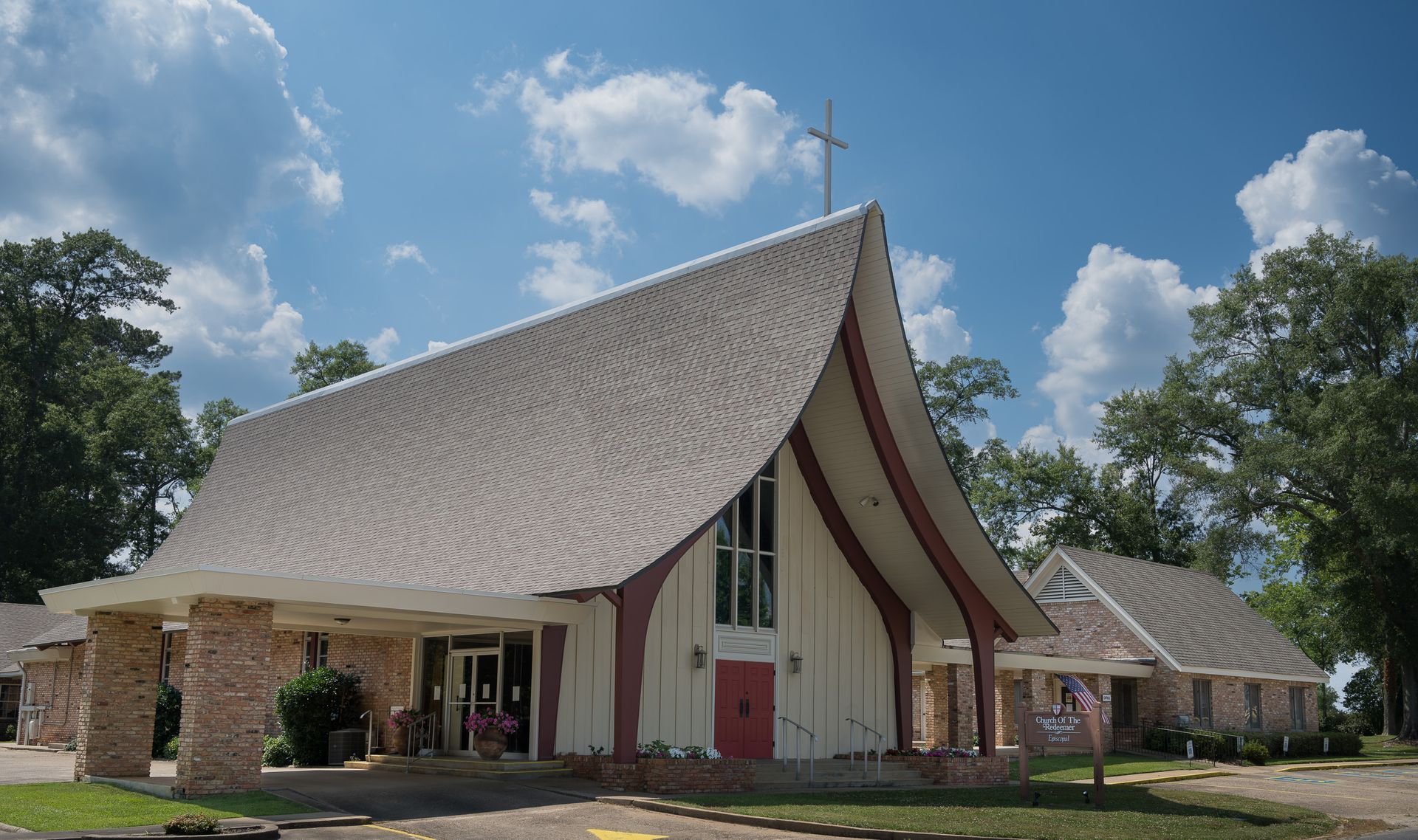 Episcopal church of the Redeemer exterior with a red door and a cross on top