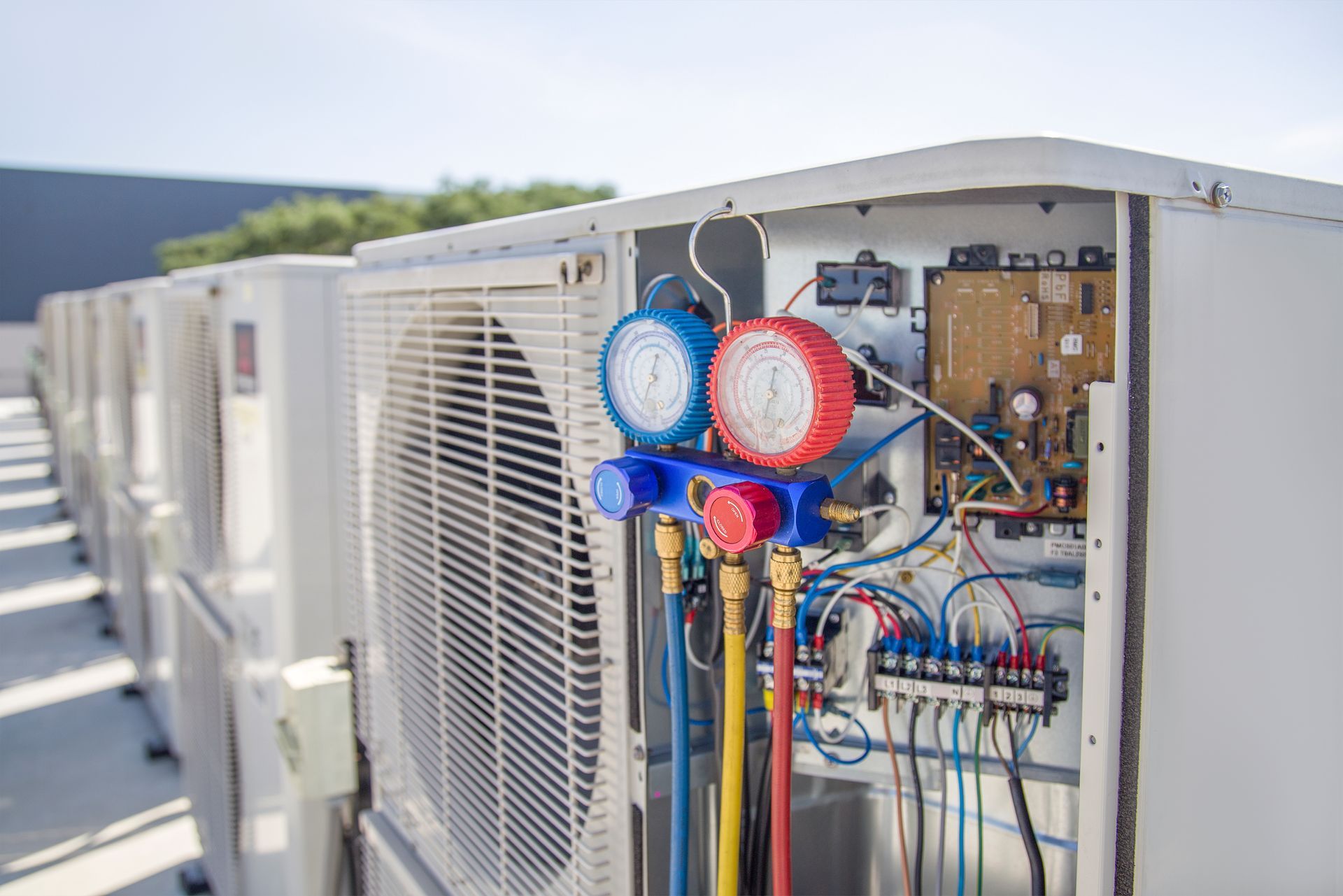 a row of air conditioners with gauges attached to them .
