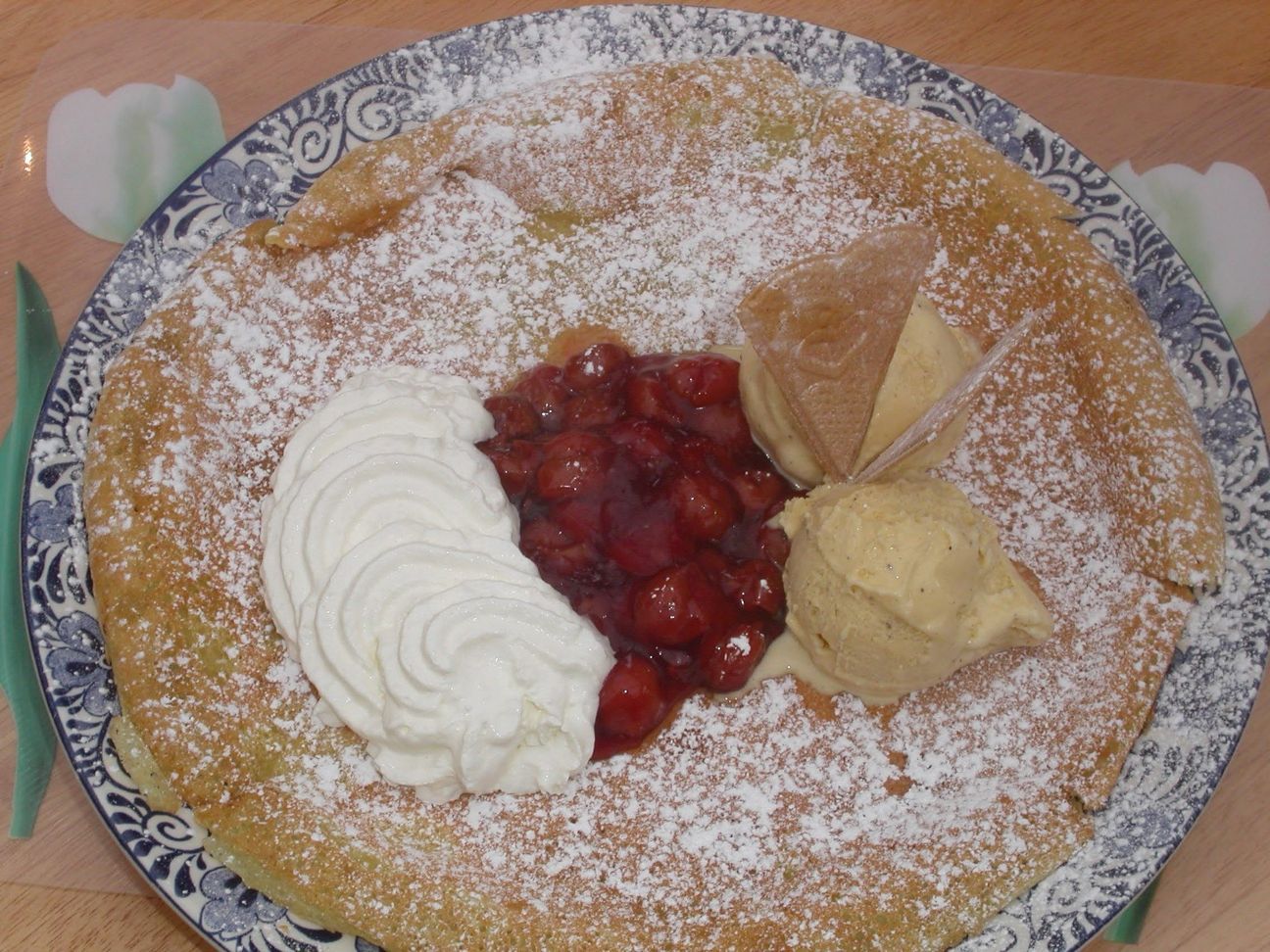 A pancake with whipped cream and cherries on top
