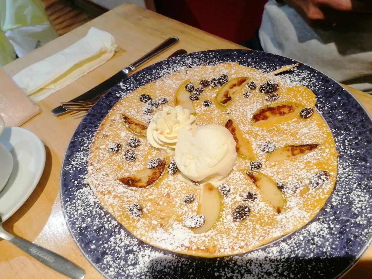 A pancake with ice cream and powdered sugar on top