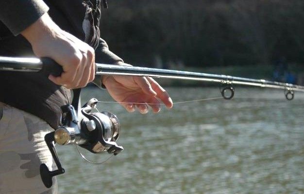 A person is holding a fishing rod over a body of water