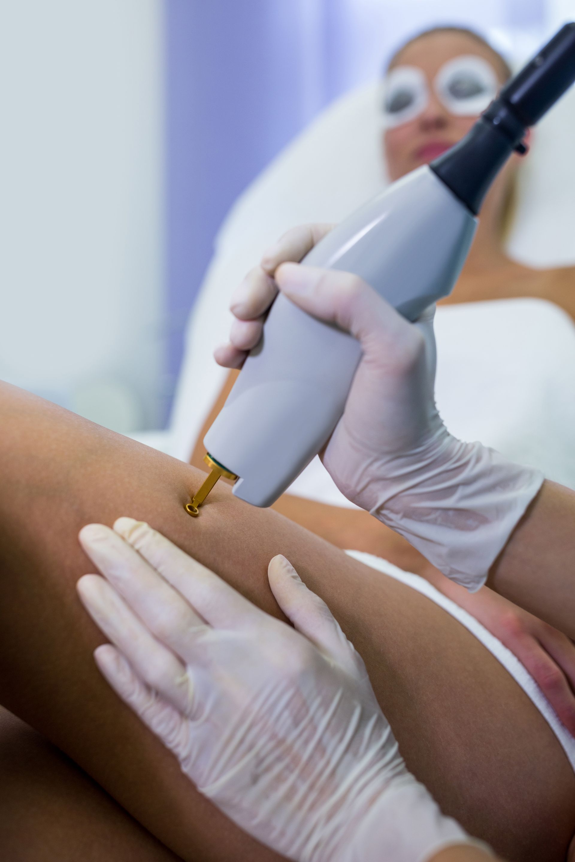A Woman In A Bikini Is Getting A Spray Tan On Her Back — Skin Care Centre of Cairns In Cairns City, QLD