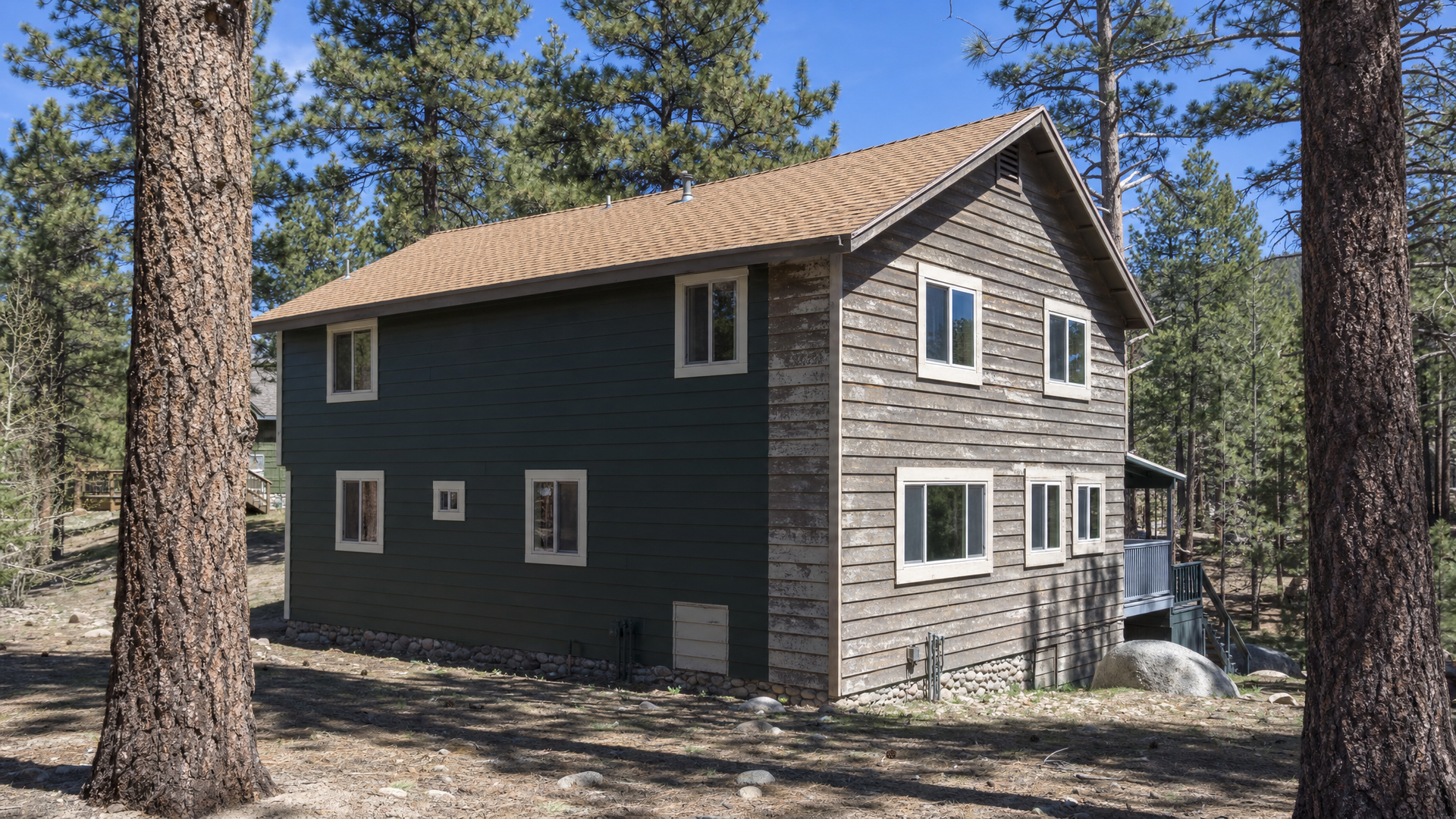 A Big Bear cabin showing faded, sun-facing paint next to a freshly painted, shaded wall