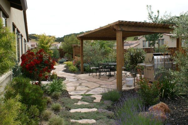 A patio with a wooden pergola and a grill | Pavers in Davis, CA