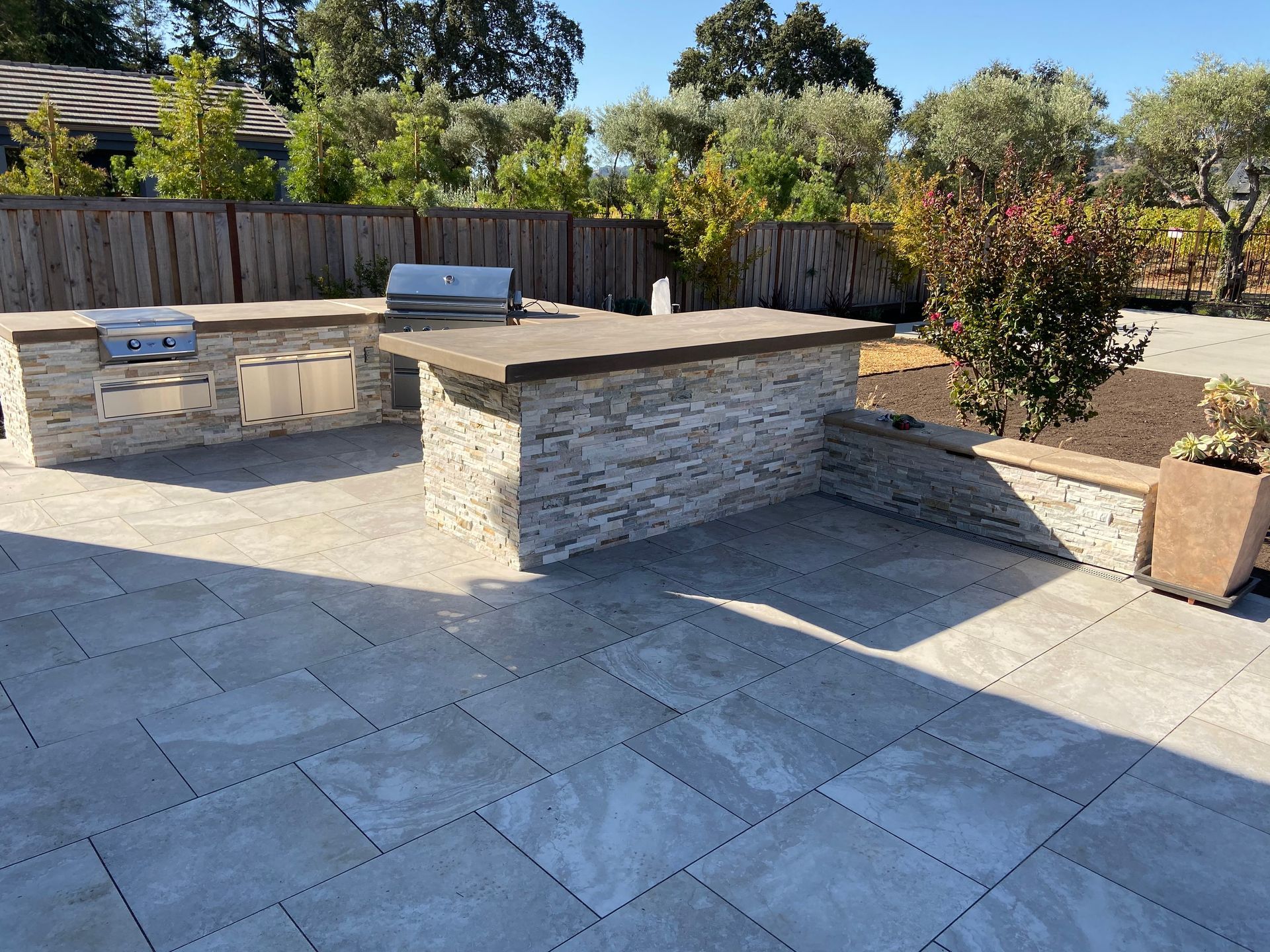 A patio with a grill and a stone wall | Outdoor Kitchen in Davis, CA