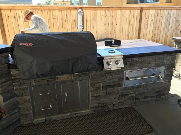 A man in a cowboy hat is working on an outdoor kitchen | Landscape Design in Davis, CA