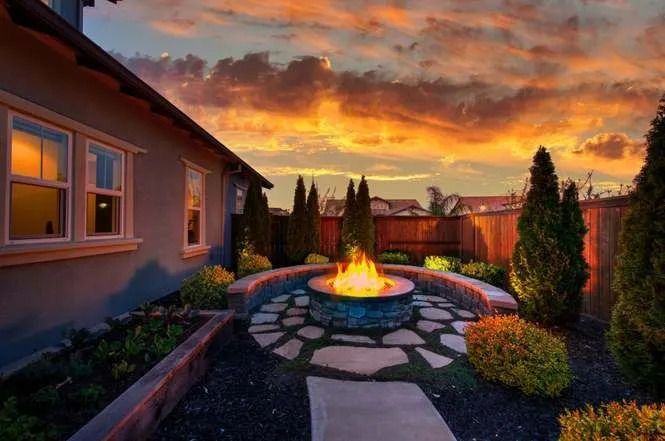 A fire pit in the backyard of a house at sunset | Landscape Design in Davis, CA