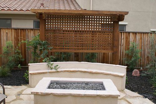 Stone fire pit with a bench & pergola, crafted by Turfworks, Inc., a leading paver contractor in Vacaville, CA.