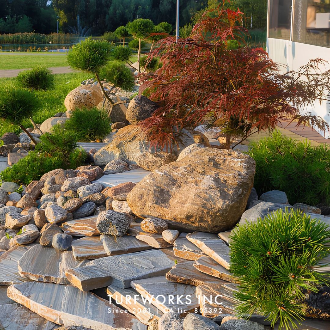 Concrete patio at dusk with stone fire pit, pergola with string lights, dining set, overlaid with Turfworks Inc logo.
