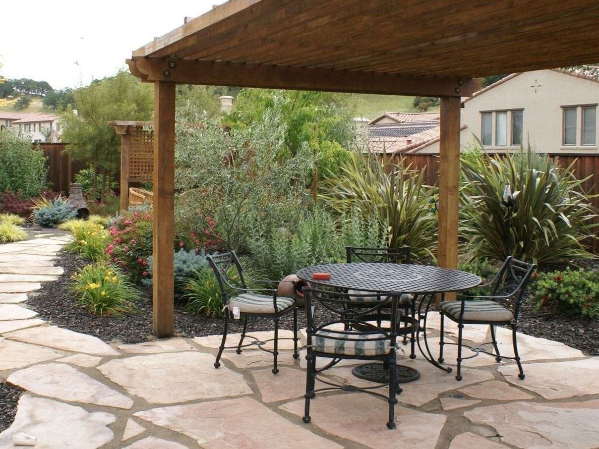 A patio with a table and chairs under a pergola | landscape design in Davis, CA