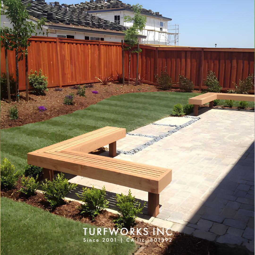 Turfworks Inc landscape contractor project with custom wood benches, stone pavers, lawn, and garden beds, logo overlay