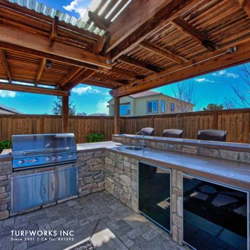 Outdoor kitchen by Turfworks Inc, a top landscape company in Vacaville, CA, with a grill and seating.