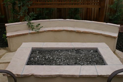 Stone fire pit with a bench, crafted by Turfworks, Inc., a leading landscape company in Vacaville, CA.
