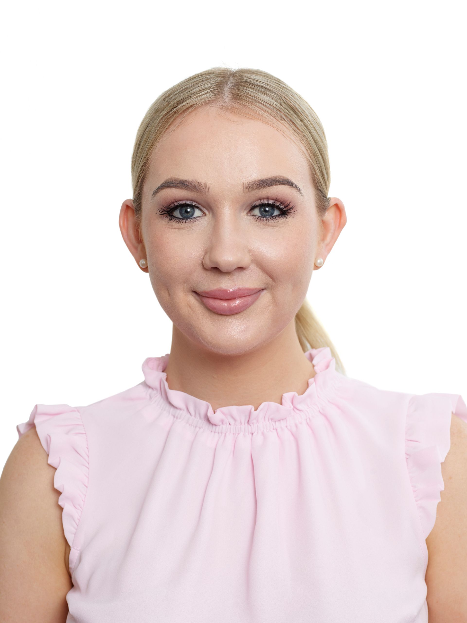 A woman in a pink shirt is smiling for the camera.