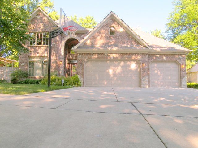 A large brick house with a basketball hoop in front of it