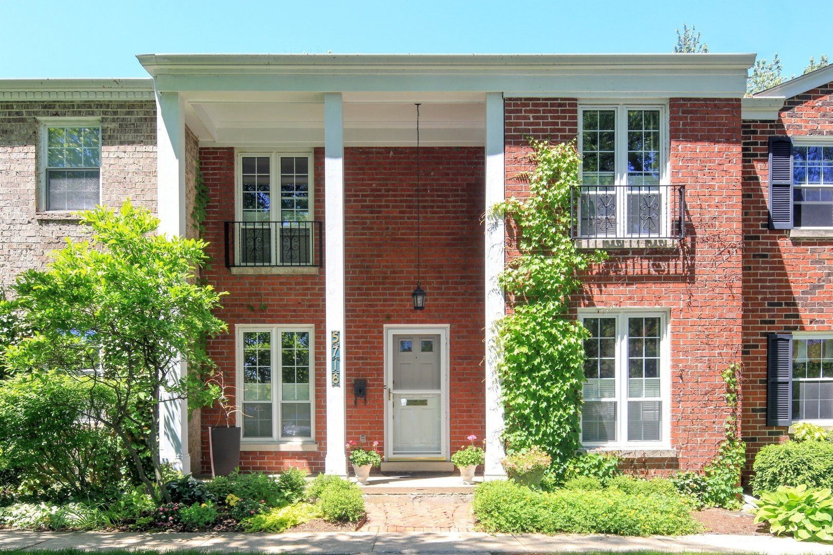 A large brick house with a porch and lots of windows