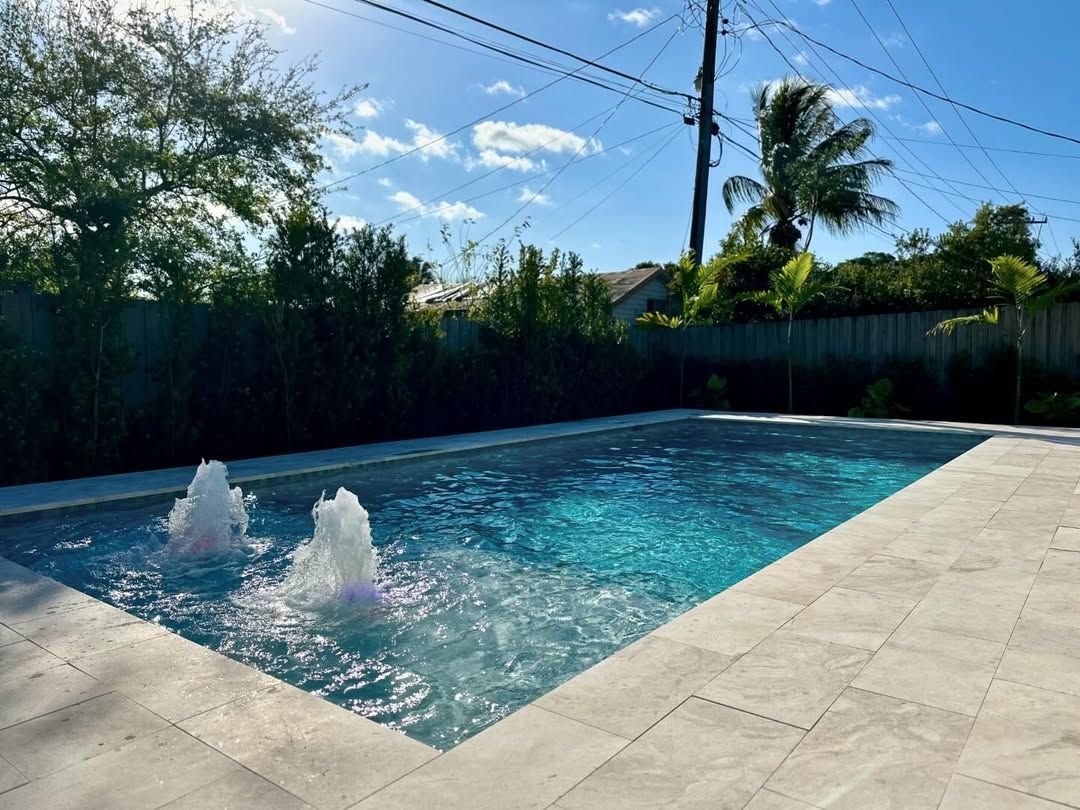 A large swimming pool with two fountains in it
