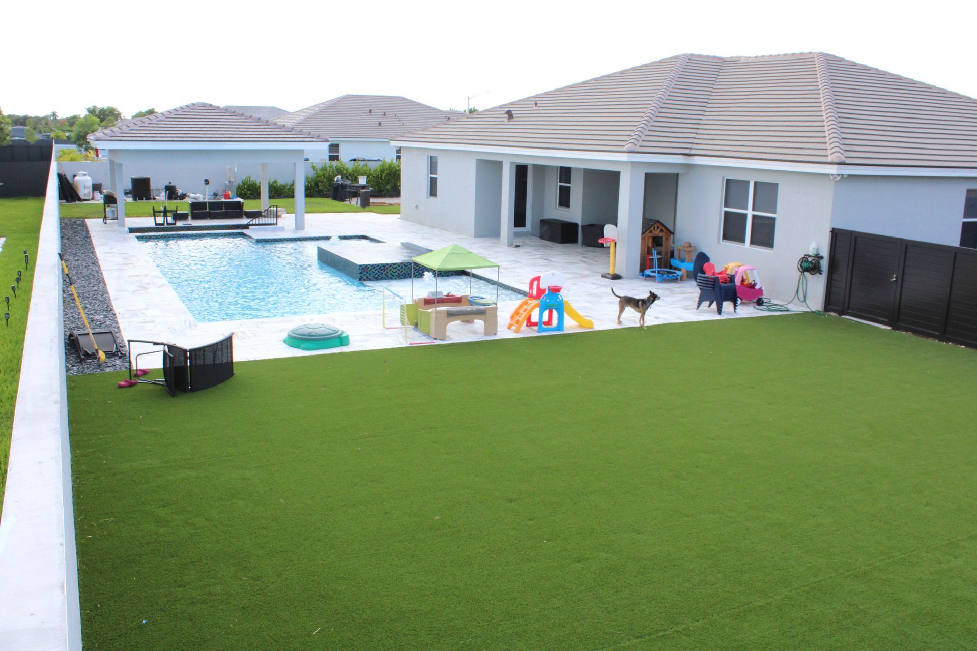 A large backyard with a swimming pool and a playground.