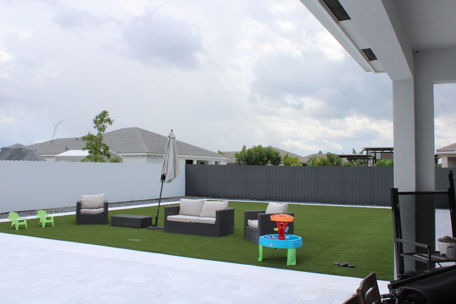 A backyard with lawn furniture and a water table