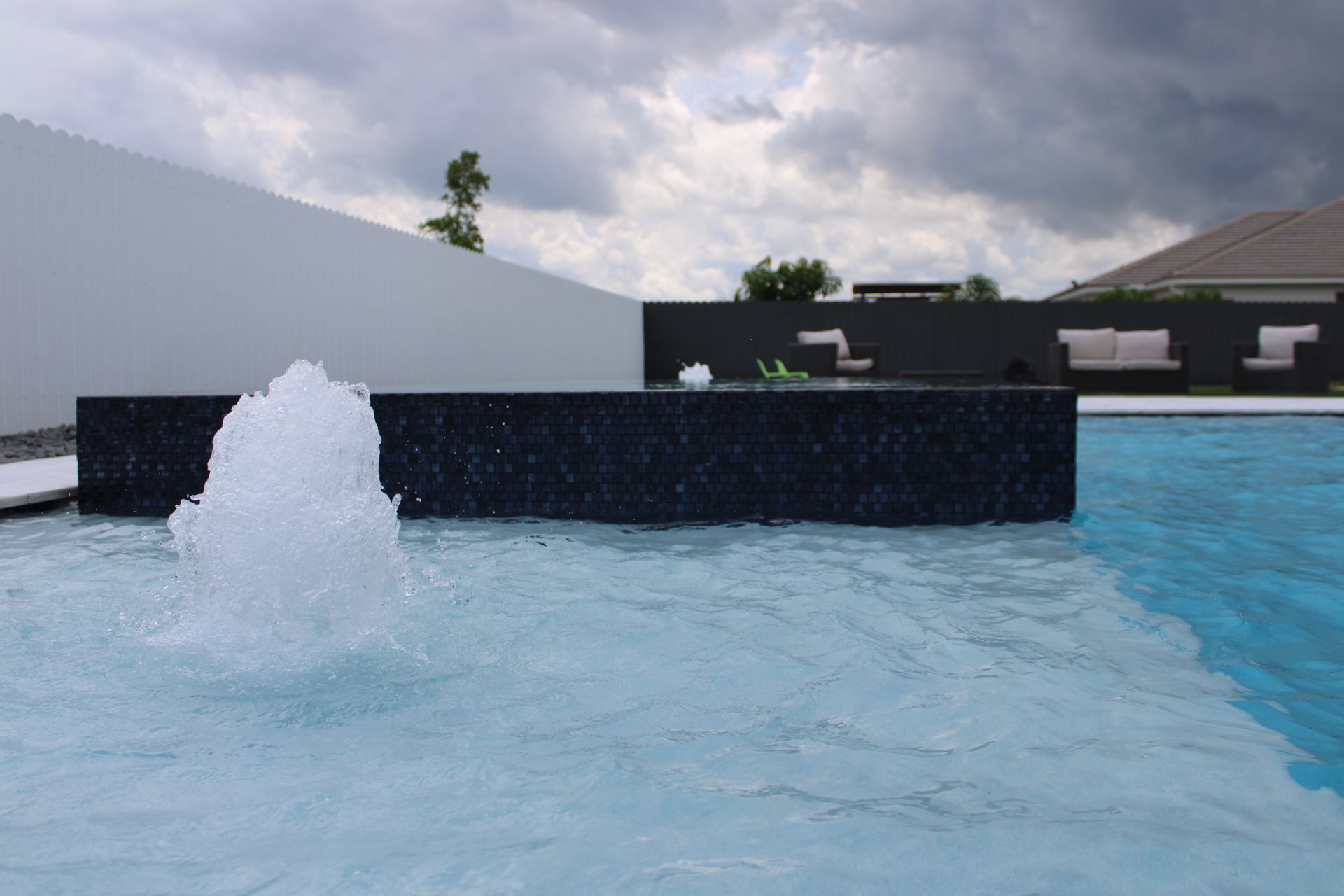 There is a fountain in the middle of the pool.