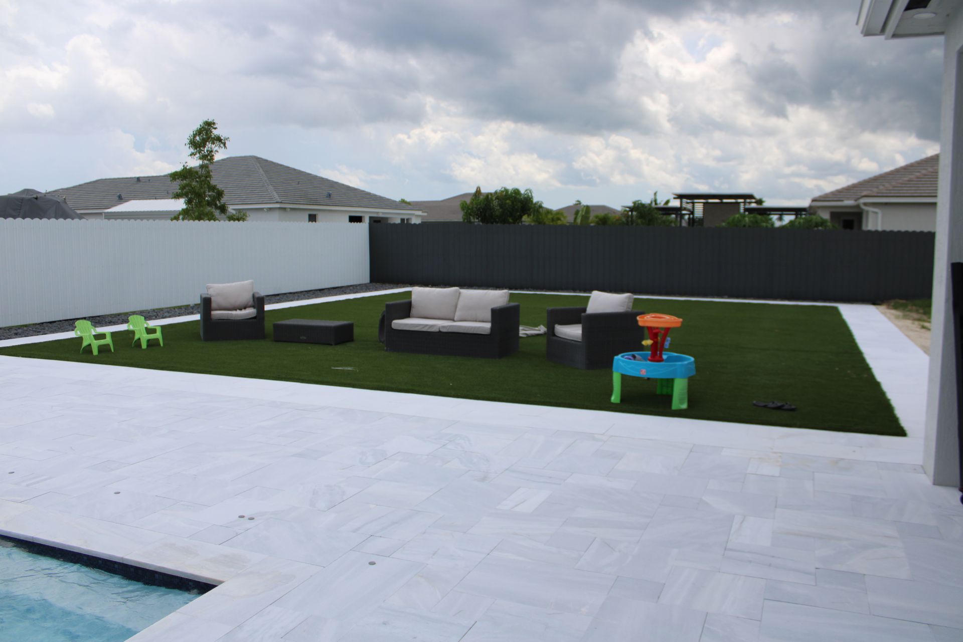 A backyard with a swimming pool and lawn furniture