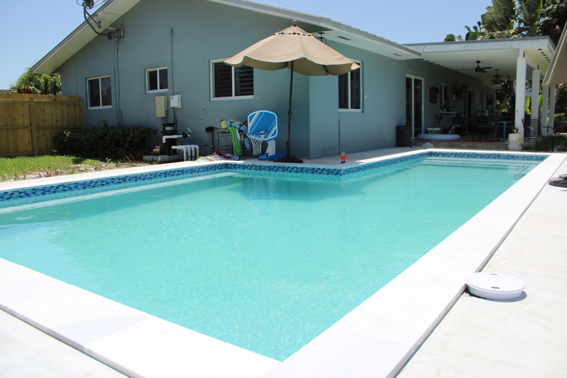 A house with a large swimming pool in front of it