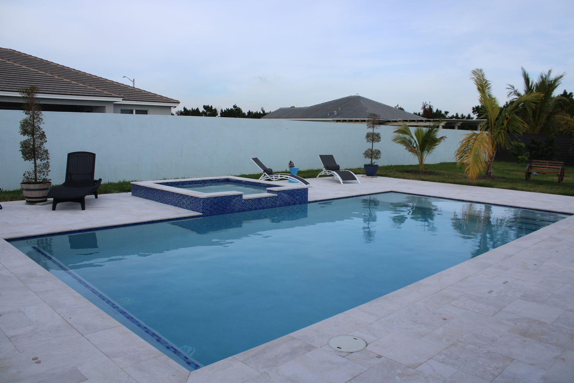 A large swimming pool with a hot tub in the middle