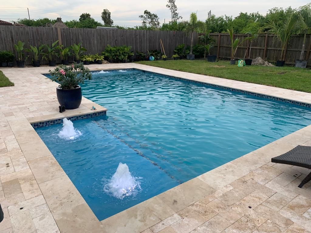 A large swimming pool with a fountain in the middle of it.
