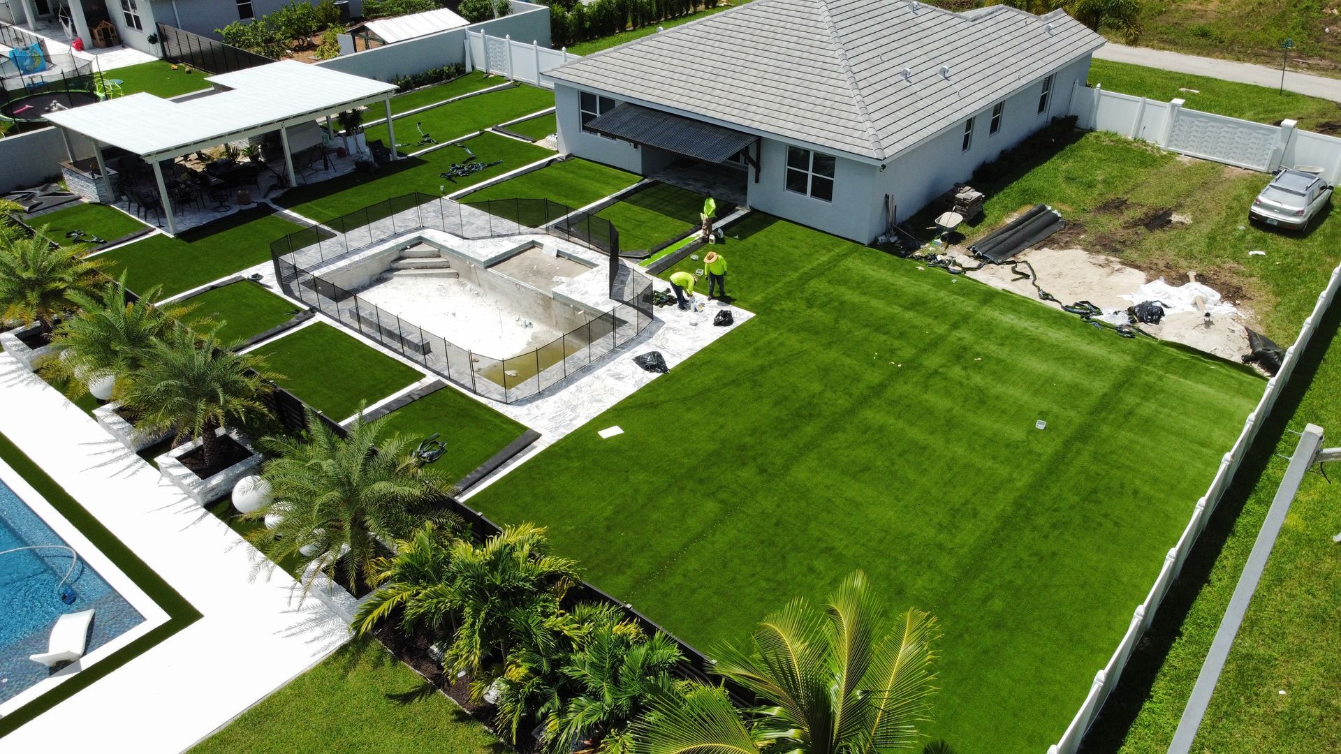 An aerial view of a house with a large lawn and a pool.