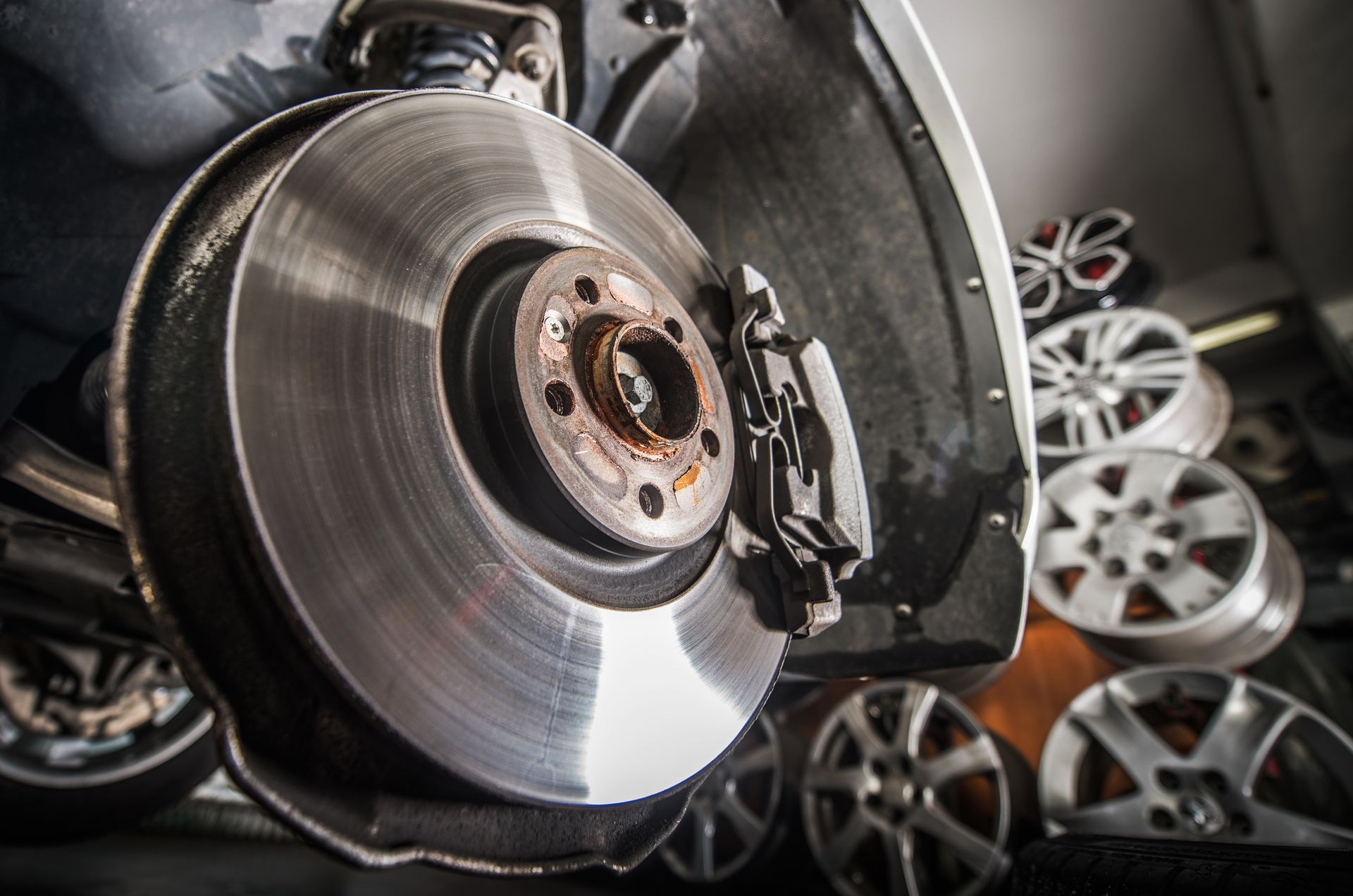 Brake repair with a new brake rotor and caliper on a vehicle.