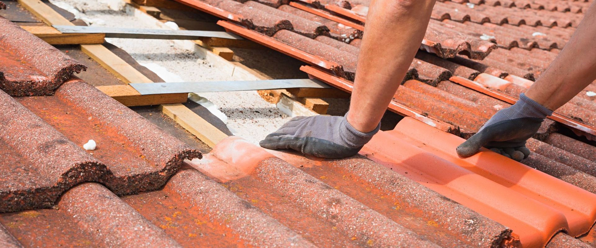 A person is installing tiles on a roof.