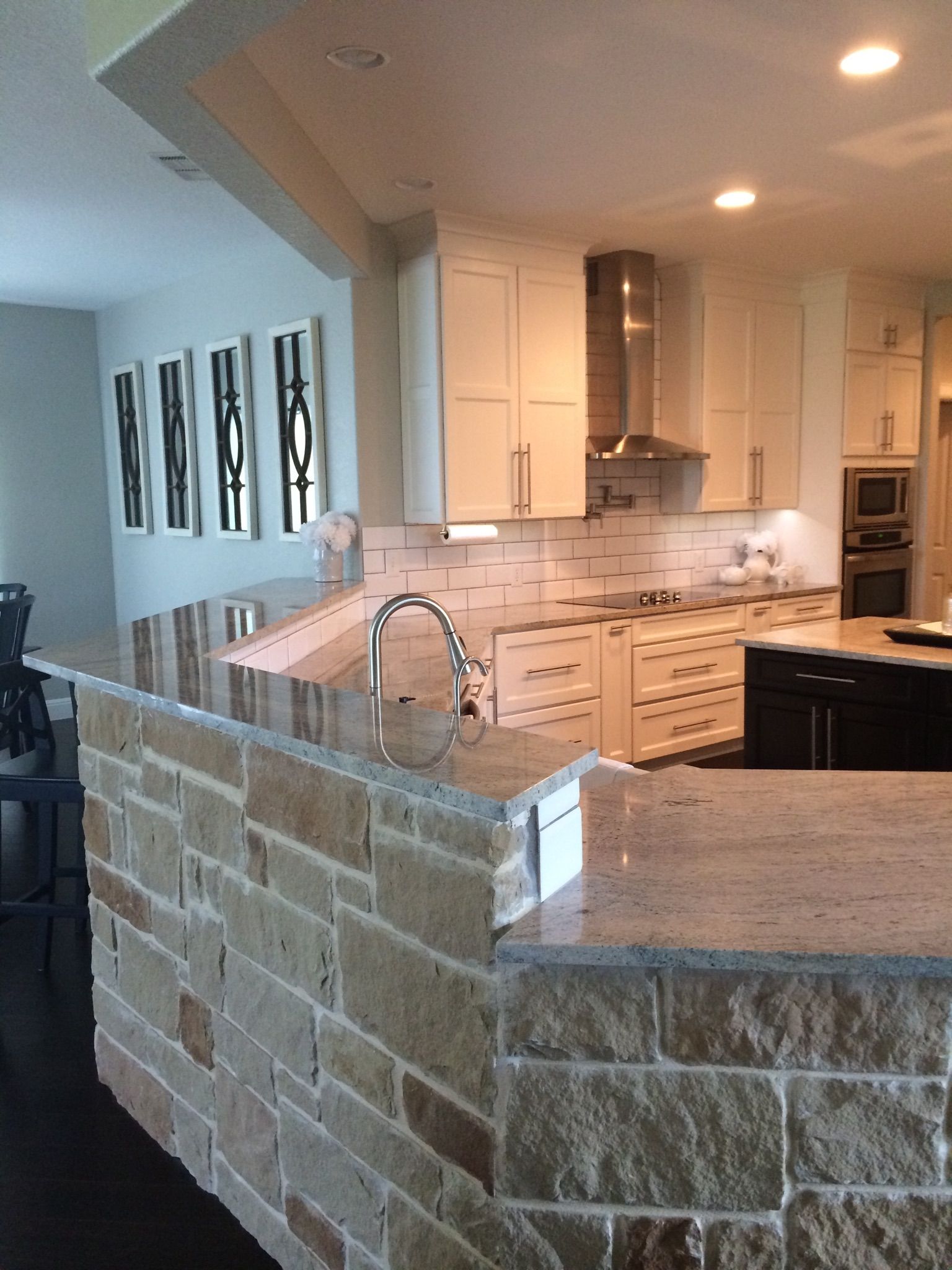 White kitchen cabinets with subway tile backsplash and granite countertops