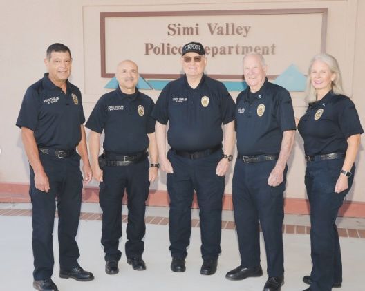 Five people in police uniforms in front of the Simi Valley Police Department sign.