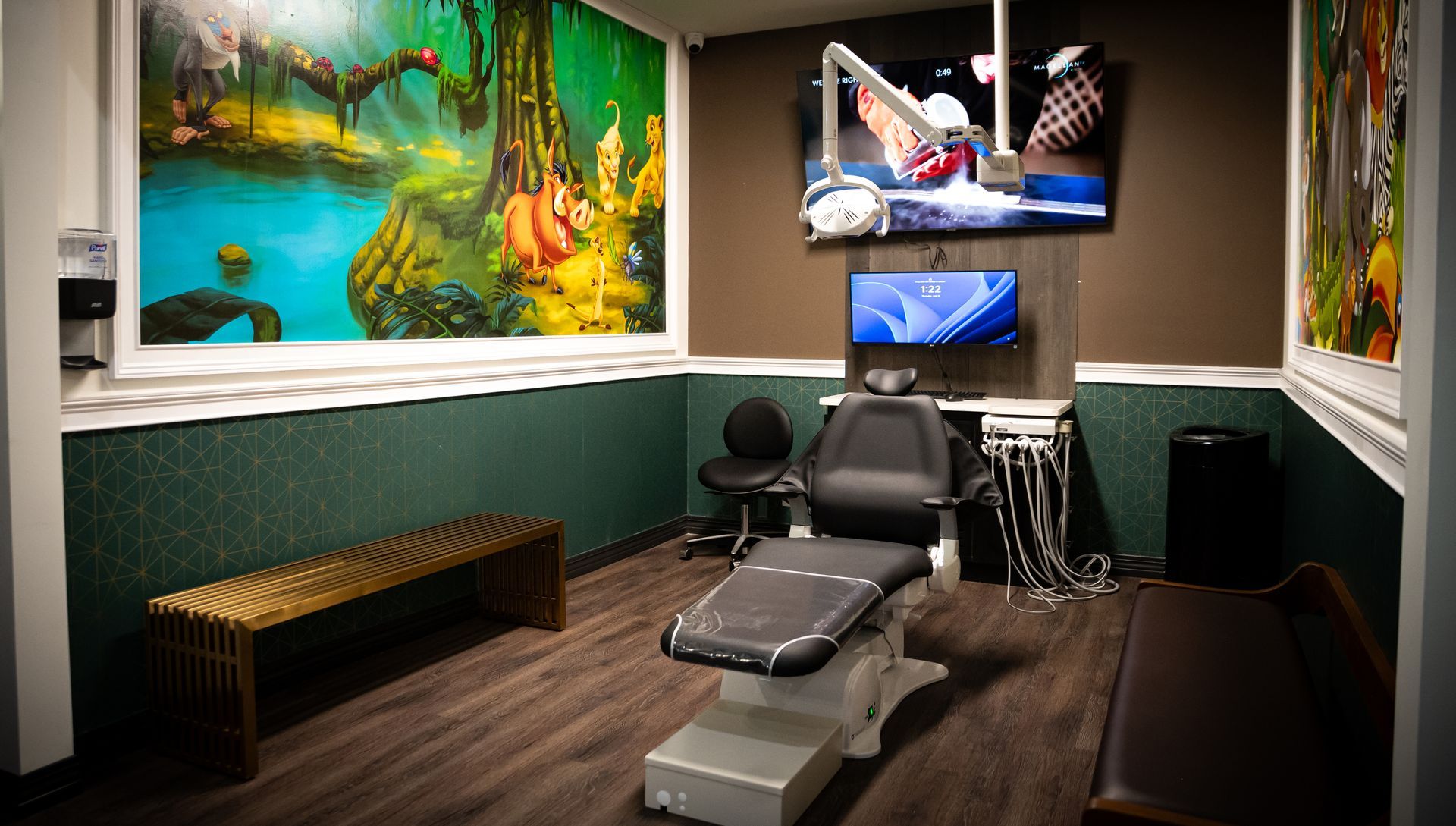Tattoo studio with two chairs, wall art, and a TV mounted above the workstation.