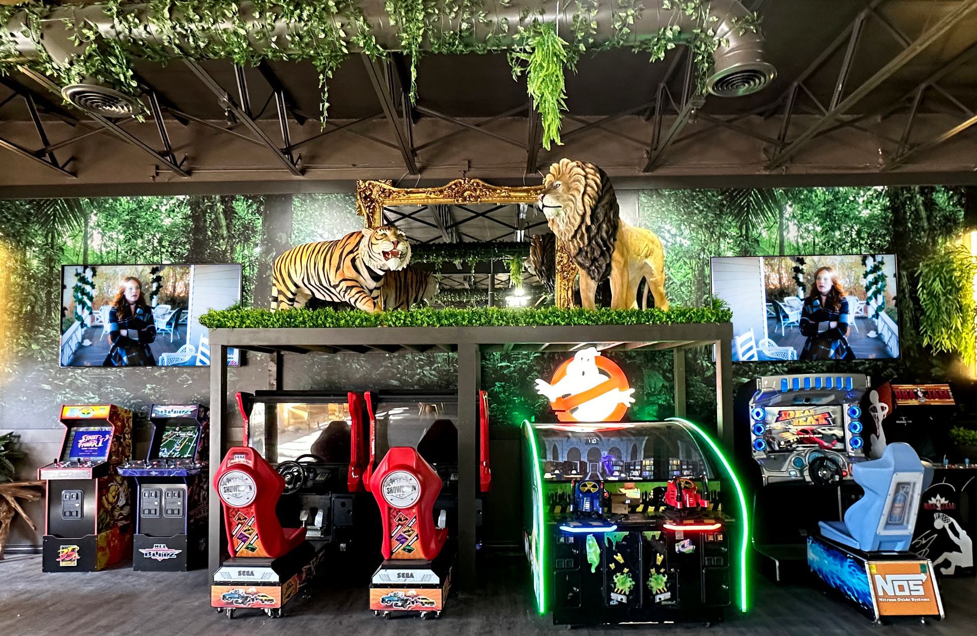 Arcade with racing and boxing game cabinets beneath tiger statues and neon lights