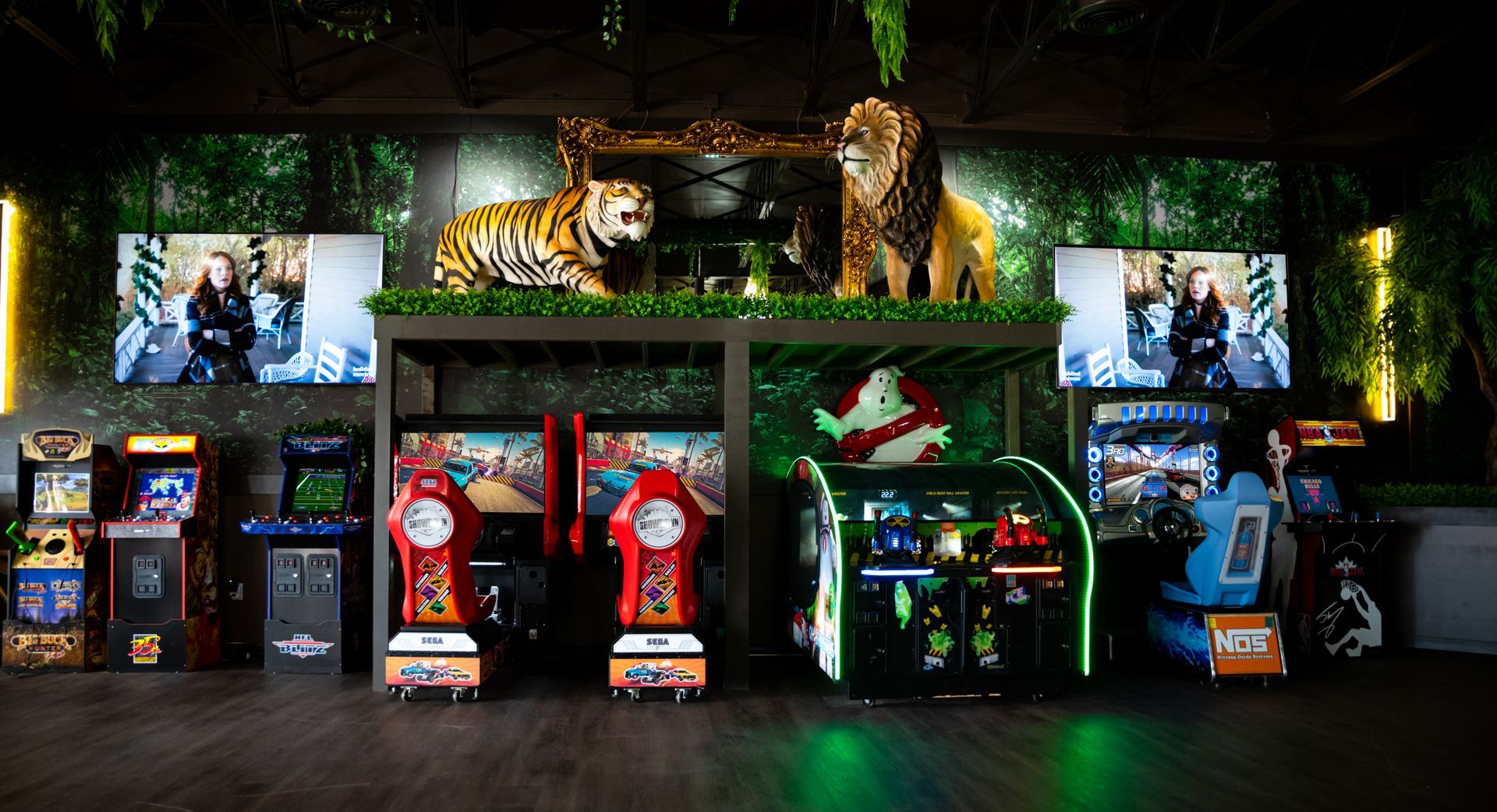 Tiger-themed arcade game display with multiple racing cabinets and jungle foliage backdrop