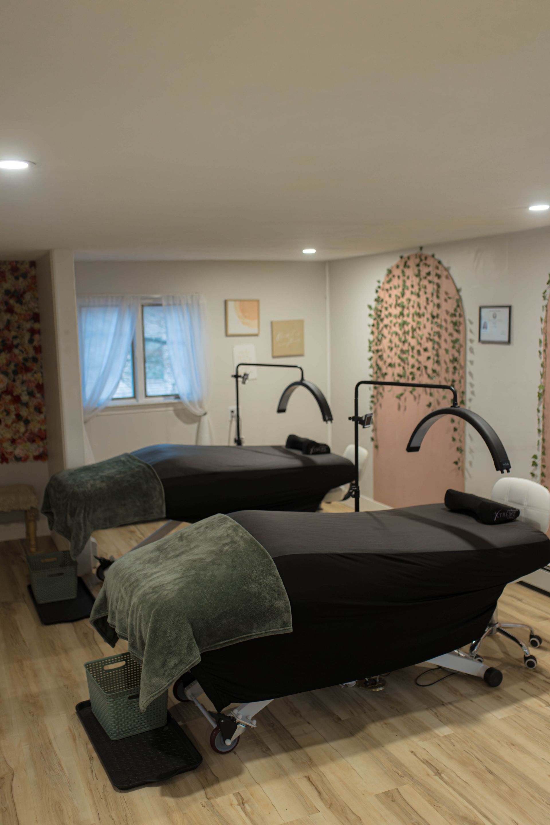 Spa room with two massage tables, lamps, and a window