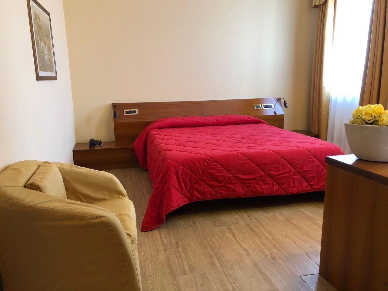 A hotel room with a bed and a chair