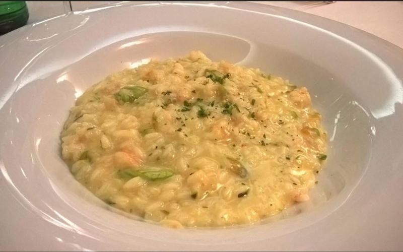 Una ciotola bianca piena di riso e verdure su un tavolo.