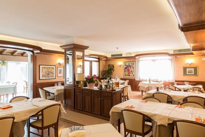 Una grande sala da pranzo con tavoli e sedie in un ristorante.