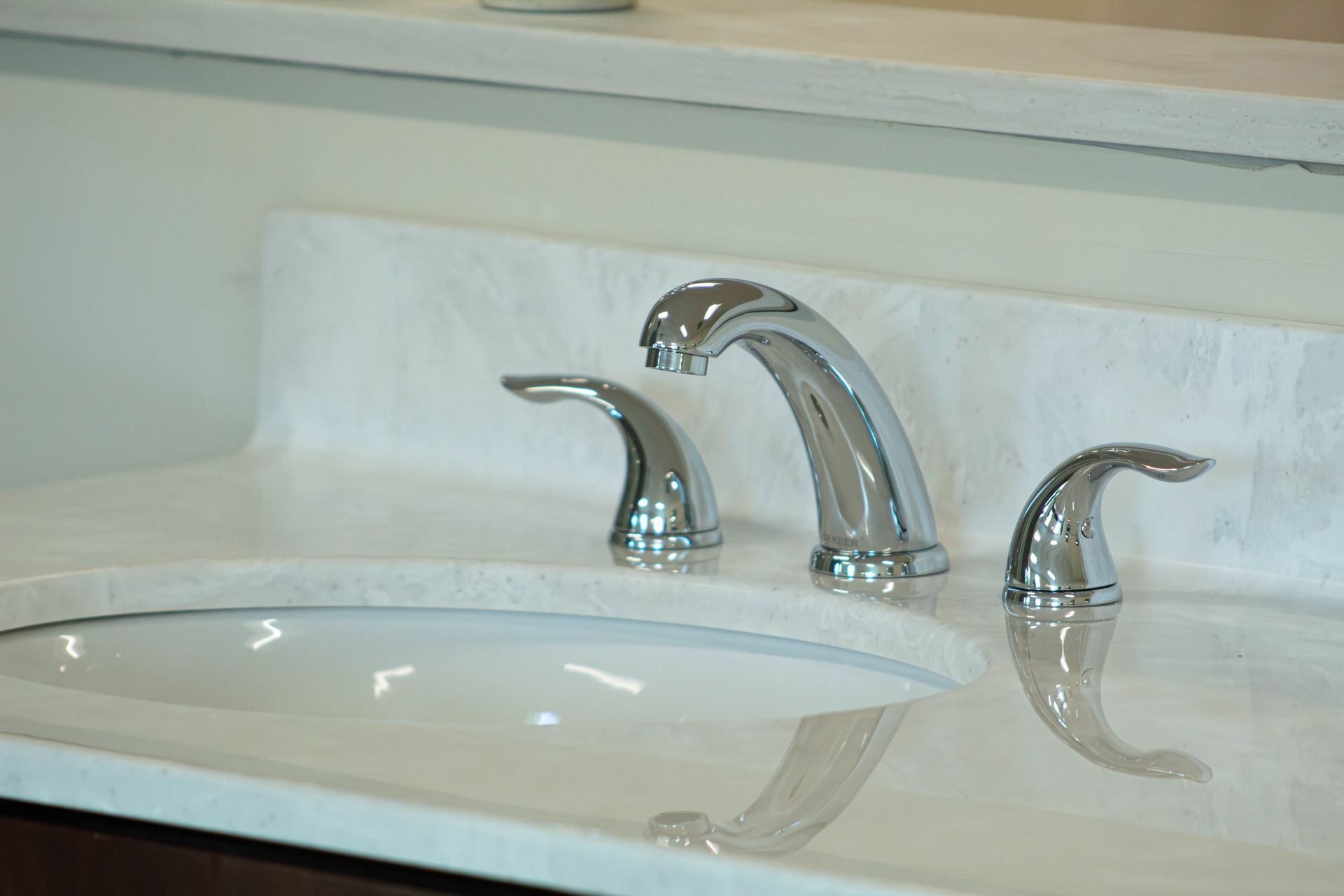 Modern bathroom sink with chrome faucet and side handles on a white countertop