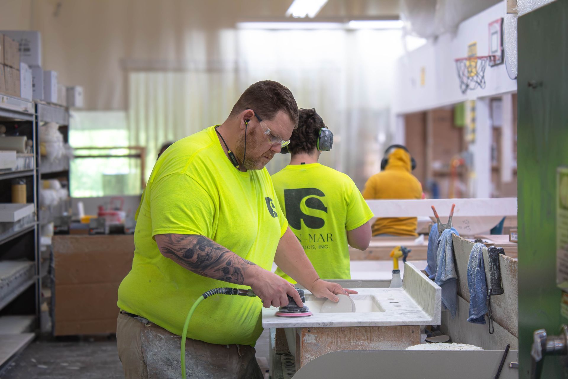 Workers in neon yellow shirts polishing seamless vanity top
