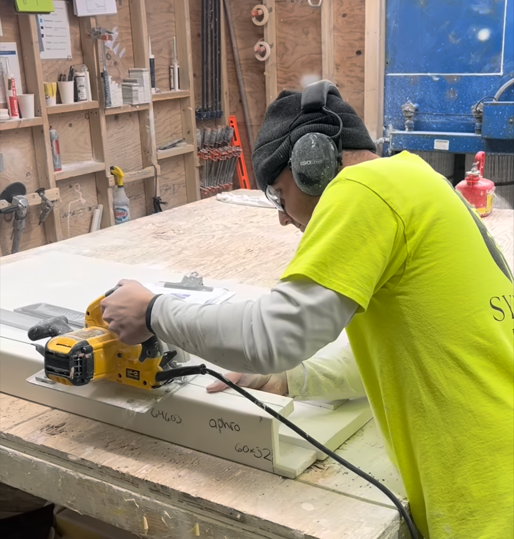 Syn-Mar employee cutting a grout-free shower wall.