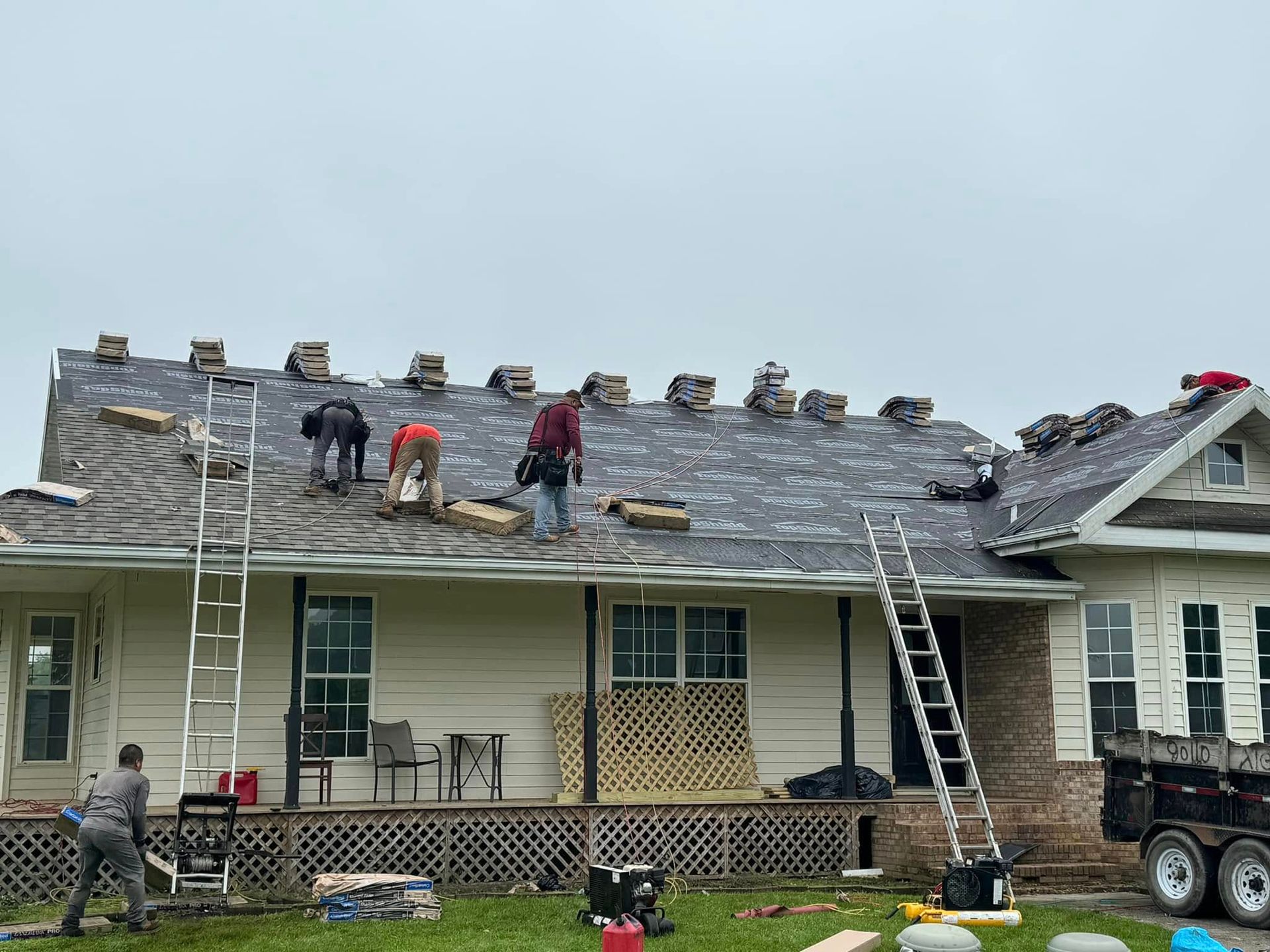 A group of people are working on the roof of a house.