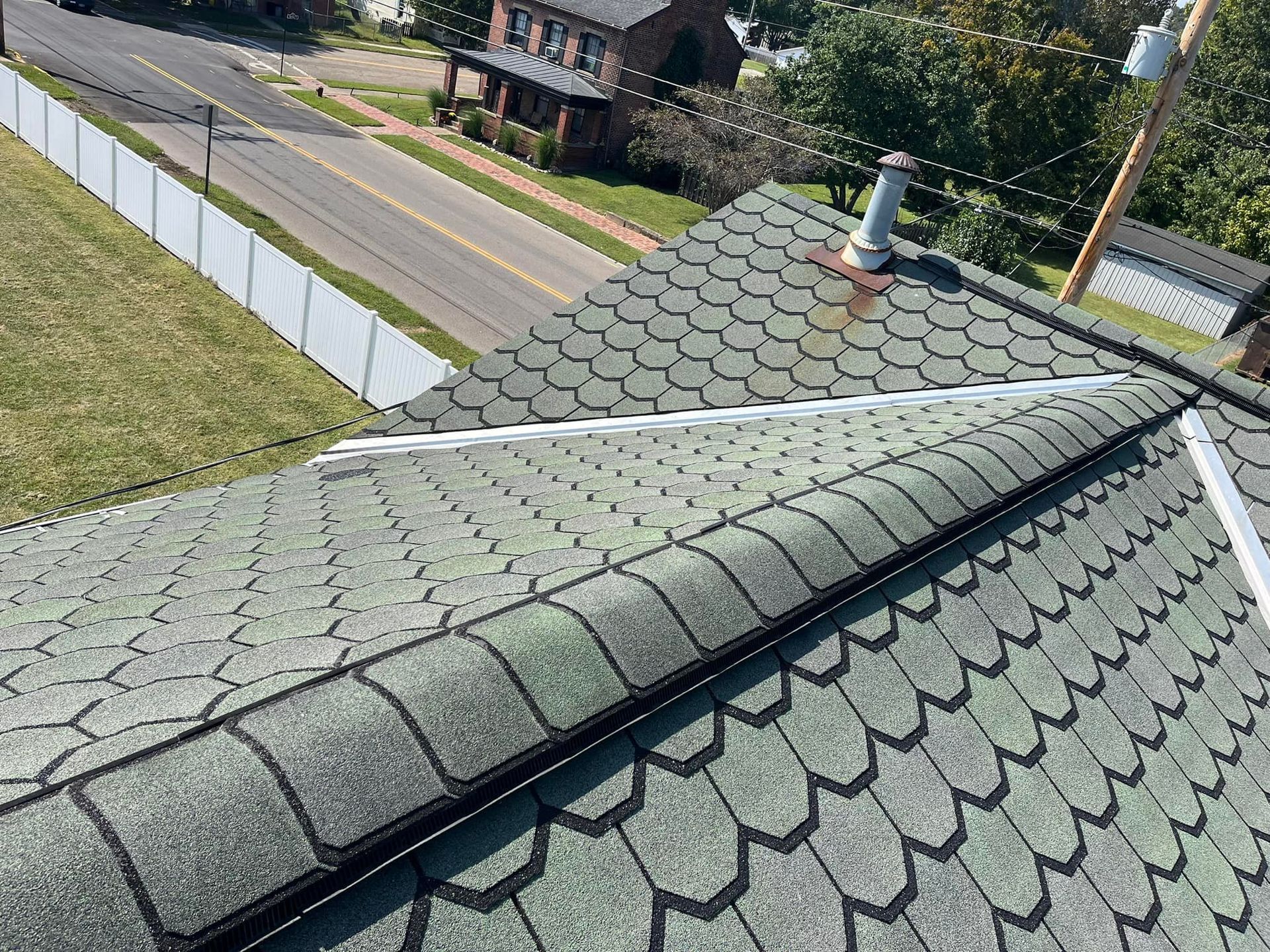 A close up of a roof with a fence in the background.